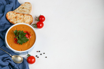 Vegetable soup with lentils on a wooden background. Served with chopped cherry tomatoes and herbs....