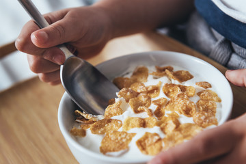 hands of a little girl holding a bowl with cereal