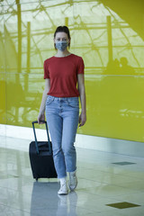 Fototapeta na wymiar Woman wearing protective mask in airport, Coronavirus contagion fears concept