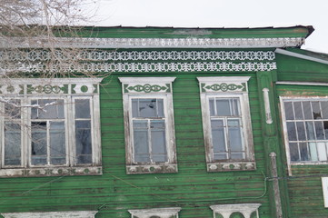 facade of an old ruined wooden rural house decorated with beautiful carvings