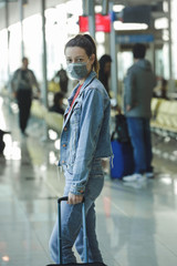 Woman wearing protective mask in airport, Coronavirus contagion fears concept