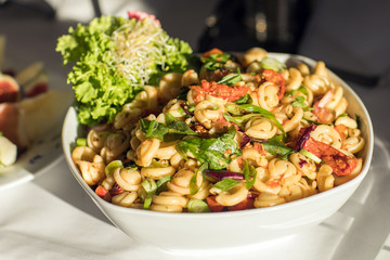 Pasta with fresh vegetables on white plate