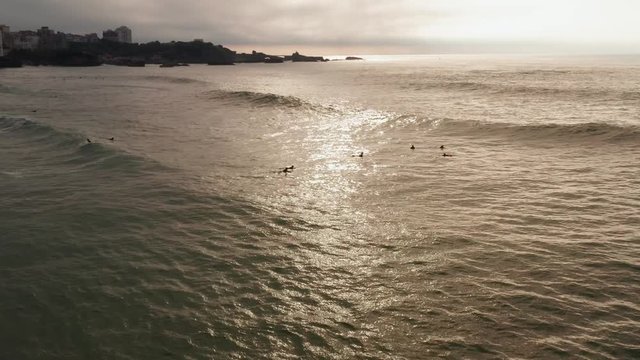 Drone flight over sufers at sunset. Biarritz, France.