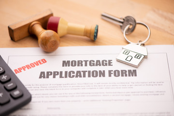 Approved mortgage loan agreement application with house shaped keyring