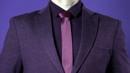 Close up of businessman in purple suit confident on dark blue background.