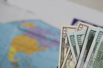 Hundred dollar and fifty dollar bills. Against the background of a world map. It shows the silhouette of North America.