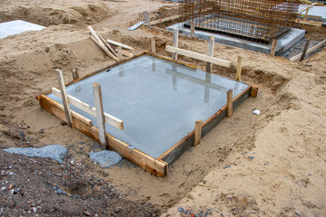  concrete foundations for the columns of a factory building are poured on a large construction site