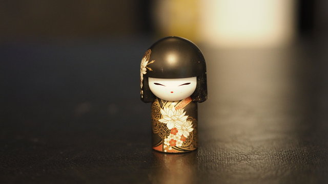 Japanese doll kokeshi black kimono on black background