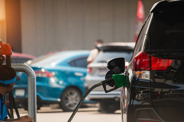 Fuel nozzles adding gasoline fuel in car at a pump gas station
