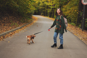 Woman with american cocker spaniel walks at autumn park.