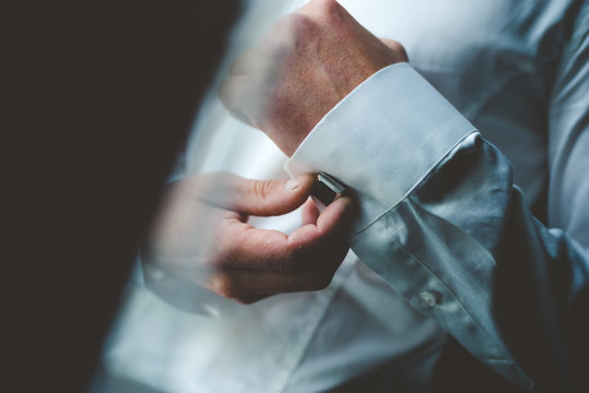 Men's Hands In A White Shirt Adjusting Red Cufflinks