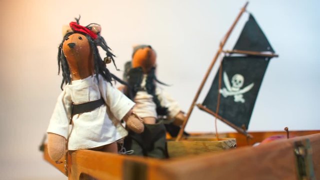 Set of pirate dolls made by hands. Nearby is a flag with a pirate sign. Homemade toy concept. Home education, self-isolation at home COVID-19. Mental relocation of children.