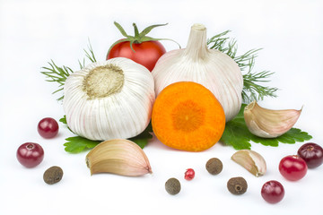 Heads of garlic, carrots and tomatoes, allspice and cranberries isolated on a white background.