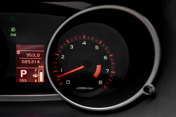 Car dashboard with speedometer and illuminated fuel consumption indicator close up. Modern electronics inside vehicle