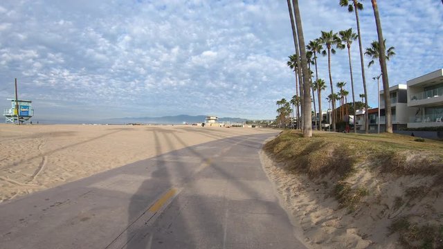 Early morning ride past homes and palm trees on the Venice beach bike path in Southern California.