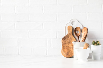 Kitchen utensils on a background of a white brick wall. Concept of the decor of the kitchen.