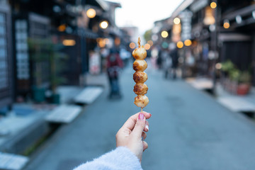 Hand of young Aisan traveller woman holding Dango, close up