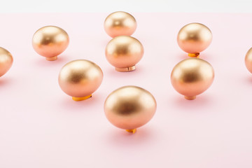 Golden eggs on a pink background. The concept of backgrounds for Easter, a symbol of the holiday.