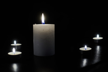 A few burning candles in the dark.