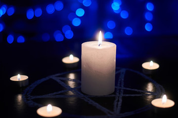 Pentagram and burning candles. The magical ritual of Satanism, invocation of spirits,...