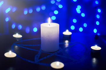 Pentagram and burning candles. The magical ritual of Satanism, invocation of spirits,...