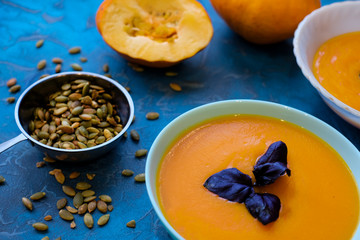 umpkin soup with purple Basil on a blue background. Top View