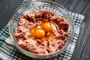 Minced meat with raw egg in a plate. Cooking meat products.