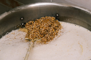 Malt is cooked in a tank. Making beer. Ground malt closeup. - obrazy, fototapety, plakaty