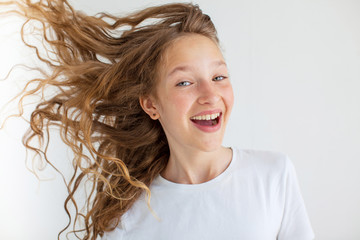 Portrait smiling young girl teen with flying curly hair