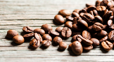 Roasted coffee beans on a wooden background, close-up, copy space.