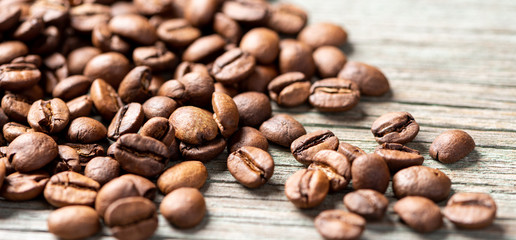 Roasted coffee beans on a wooden background, close-up, copy space.