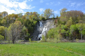 waterfall or cascade on hill with rocks in Quebec Canada