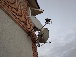 satellite dishes on a brick house