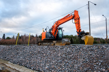 Closeup of industrial excavator working on highway construction site.