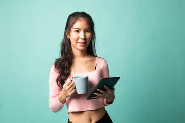 Fototapeta premium Young Asian woman with a computer tablet and coffee.