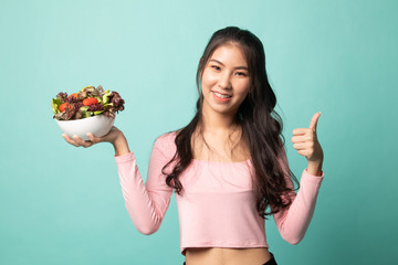 Healthy Asian woman thumbs up with salad.