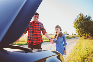 father and daughter fixing problems with car during summer road trip. Kid girl helping dad.