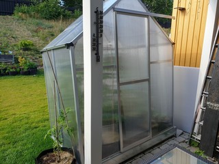 Close up view of of greenhouse on backyard. Gardening concept.
