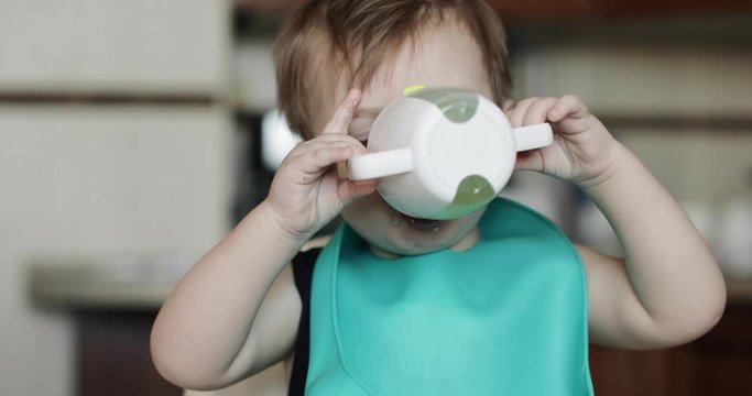 Boy drinks from a drinker