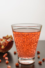 Tasty and healthy drink with basil seeds and pomegranate juice in a glass, vertical orientation