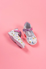 Beautiful baby shoes on a pink background. For children. Stylish pink female shoes on pastel background, copy space. New sneakers on pink background. Beauty and fashion concept. Flat lay, top view.