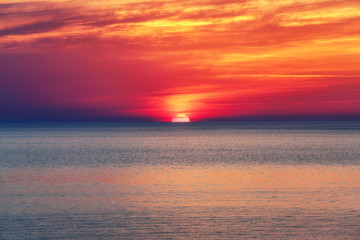 Beautiful sunset is reflecting on the sea. Sky with orange and yellow clouds. Location place...
