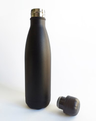 Frontal view of open elegant Thermo / Hermetic bottle made of black stainless steel isolated on black background. Close-up of beautiful thermal bottle design.