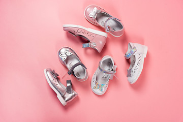 Beautiful baby shoes on a pink background. For children. Stylish pink female shoes on pastel background, copy space. New sneakers on pink background. Beauty and fashion concept. Flat lay, top view.
