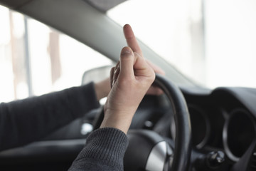 Angry driver is showing an obscene gesture close up.