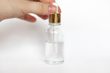 Naklejka premium Hyaluronic acid drop falls from cosmetic pipette on white background, Dropper glass Bottle Mock-Up