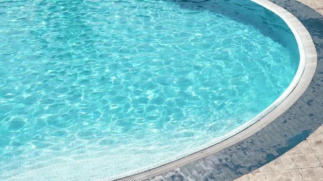 edge of the swimming pool with clear blue water at sunny summer day