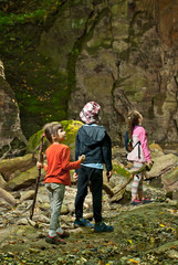Obraz premium Children walk on the mountain gorge. Hike to the source of the river. Friendly walk of children in the mountains.