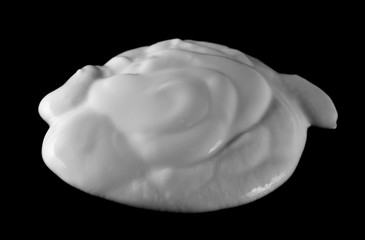 Spilled yogurt puddle isolated on black background and texture, side view
