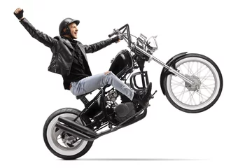 Wall murals Motorcycle Happy young male biker riding a custom motorbike with one wheel up and gesturing with hand